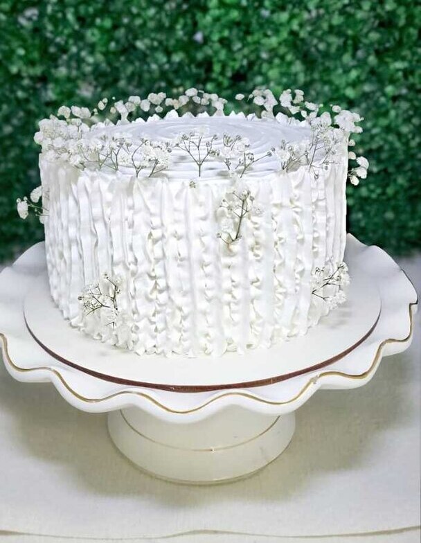 Bolo branco com babados verticais e flores de mosquitinho