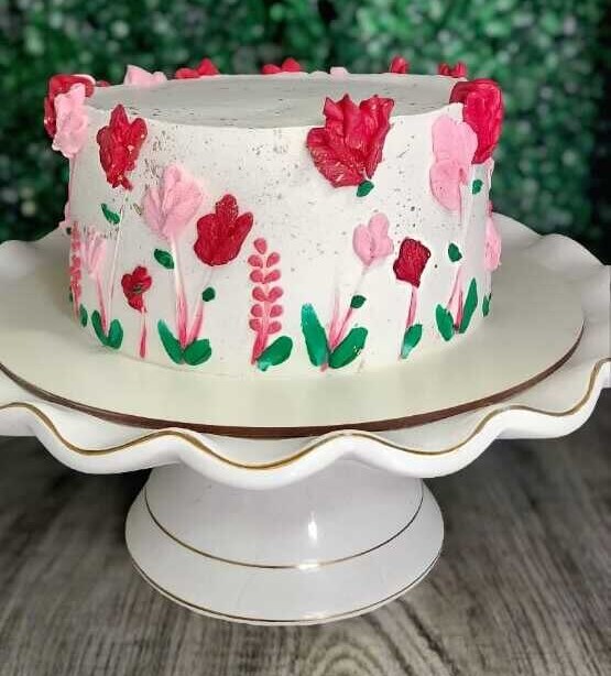 Bolo branco decorado à mão com tulipas em tons de rosa